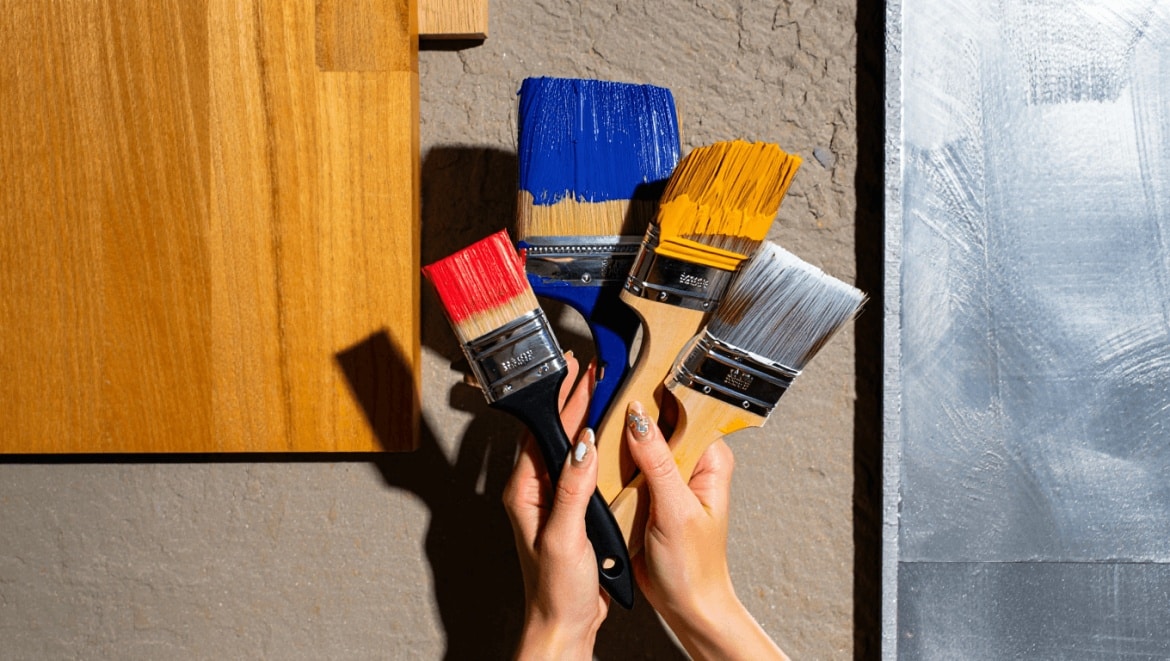 Un homme en blouson cuir noir choisissant une peinture dans une quincaillerie