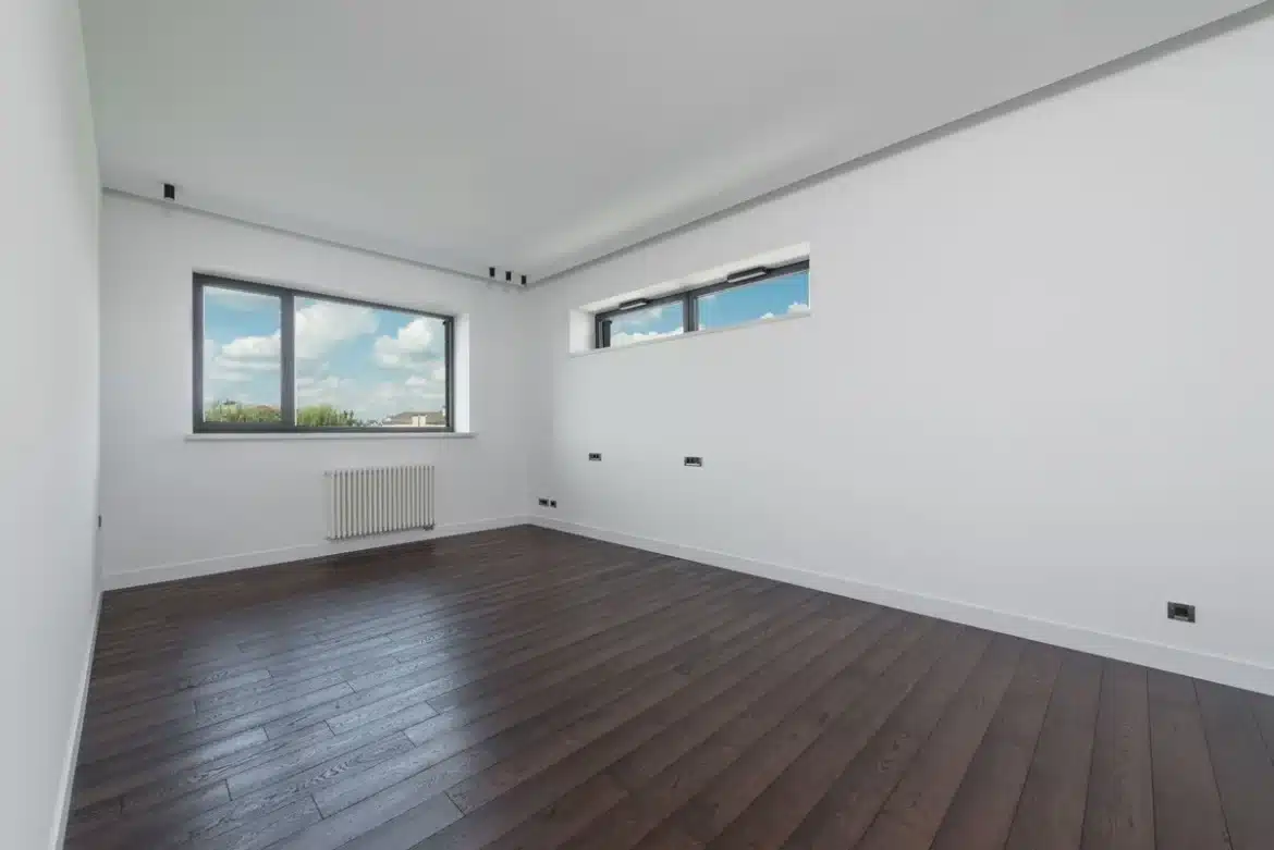 Main d'une personne ajustant un thermostat mural dans un logement pour réguler la température