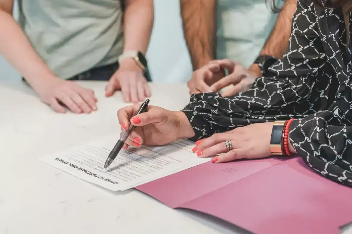 Deux personnes signant un contrat de cautionnement locative à un bureau