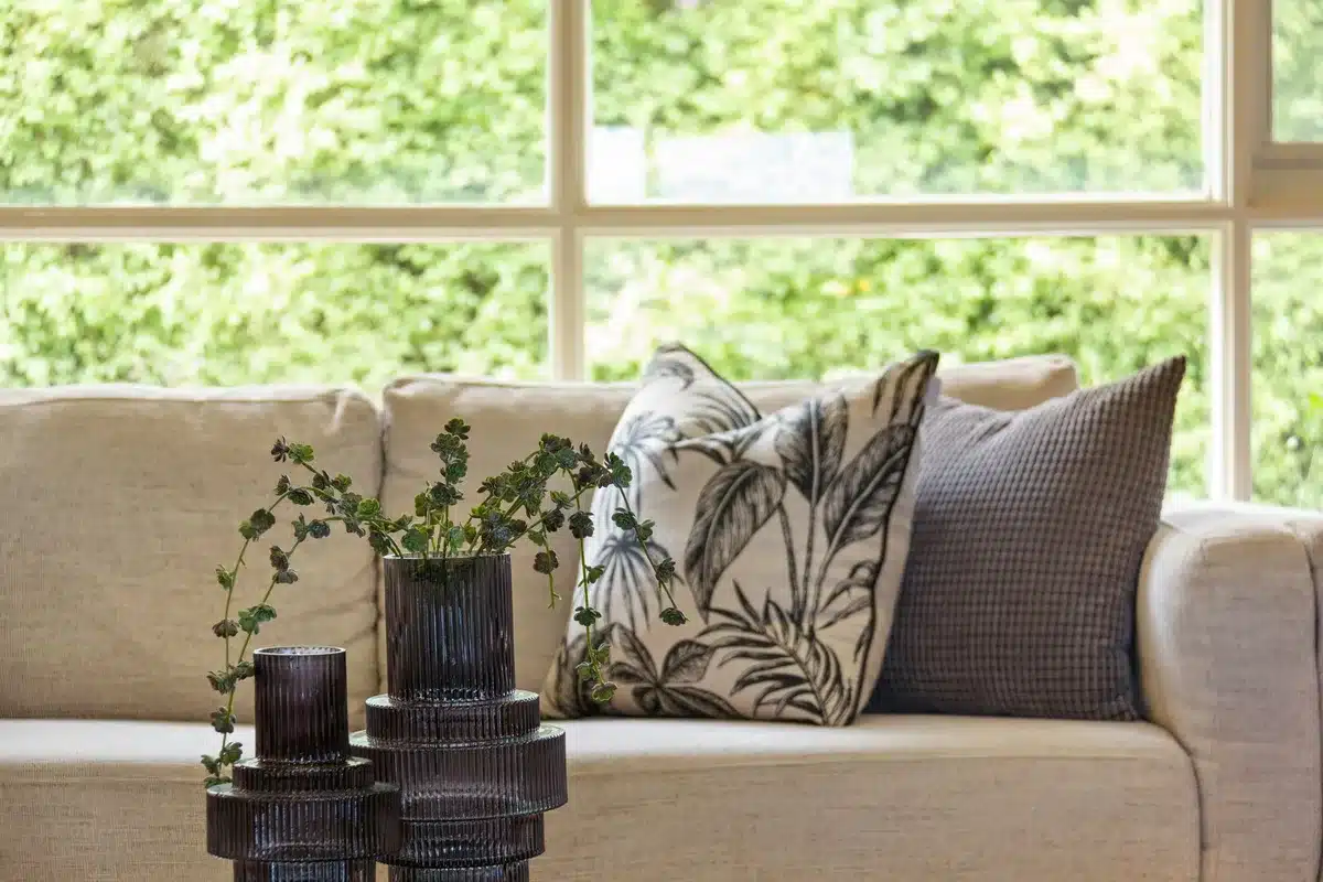 Coussin à motif léopard posé sur un canapé neutre dans un intérieur épuré