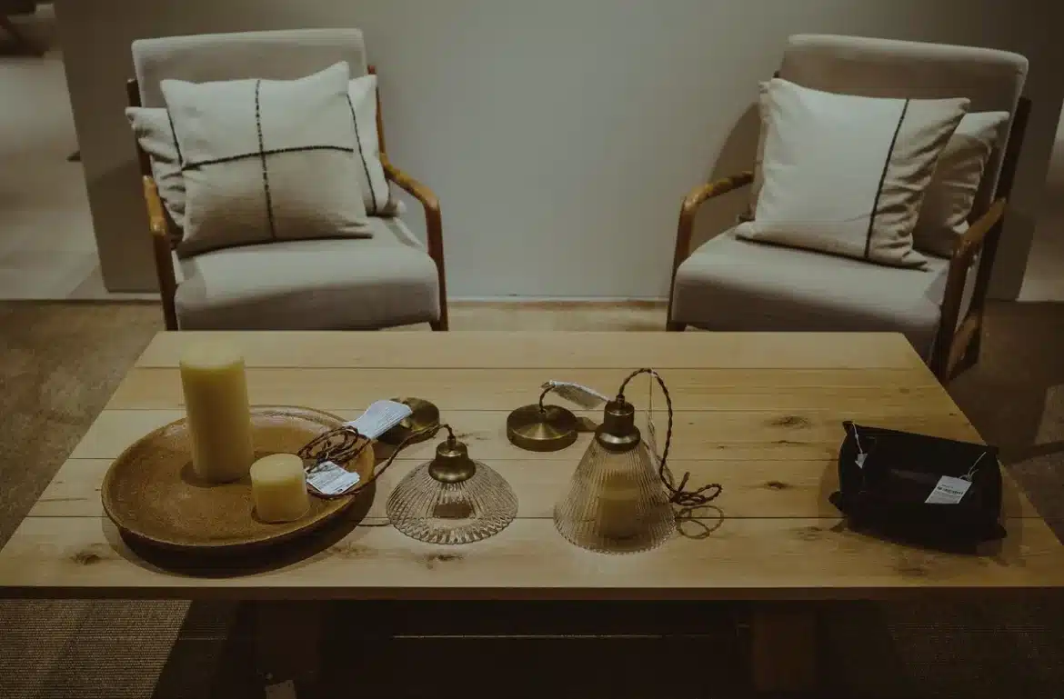 Intérieur automnal avec coussin à rayures et objets texturés sur mobilier neutre, tons chauds