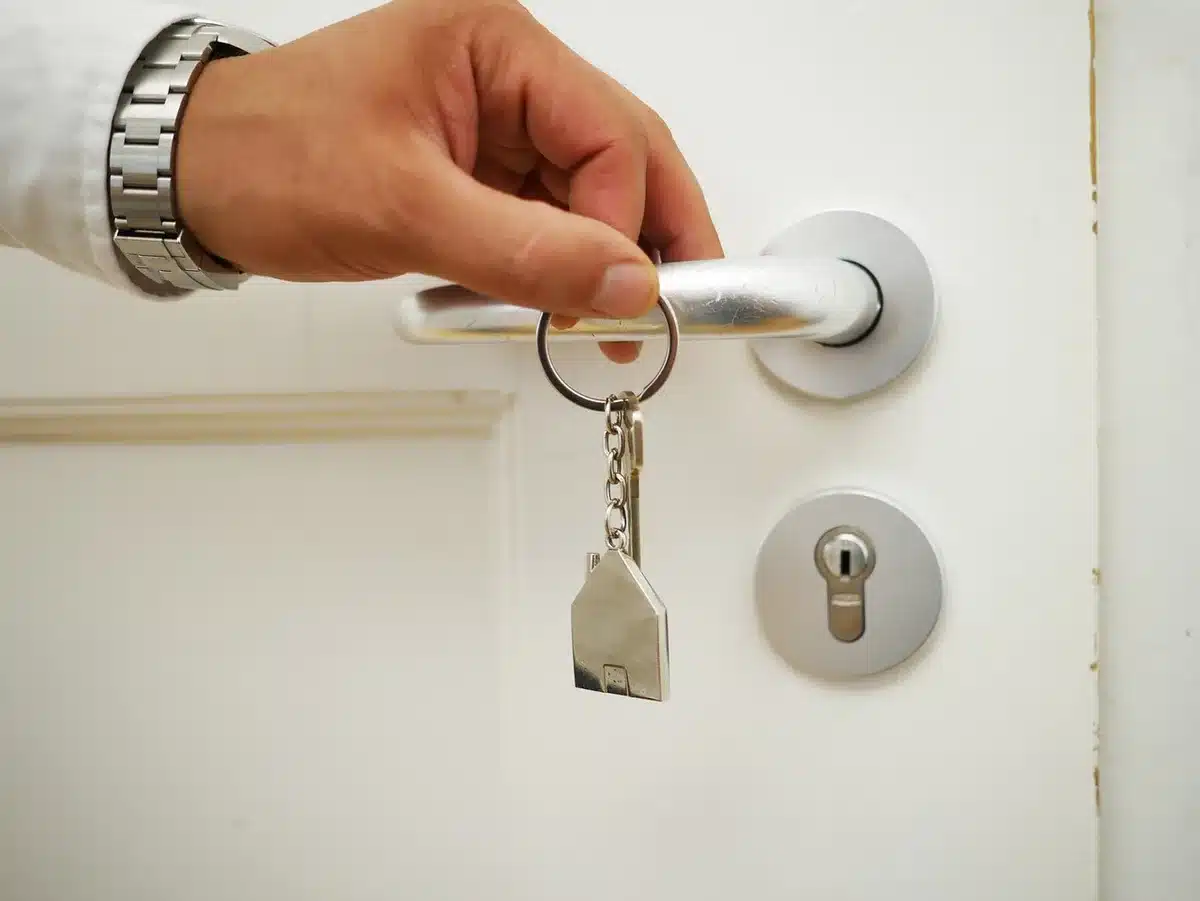Personne signant un contrat de location avec clés et dossier