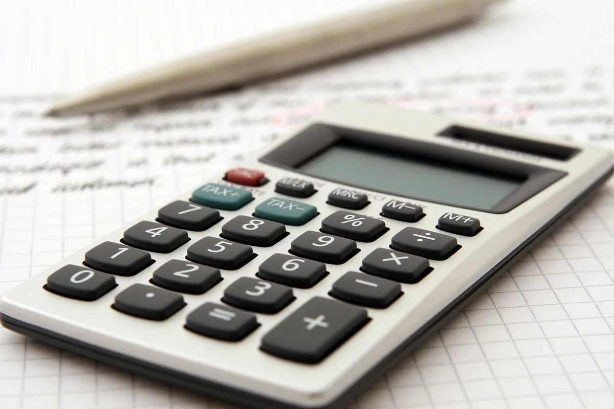 Contrat de location et stylo posés sur une table avec calculatrice
