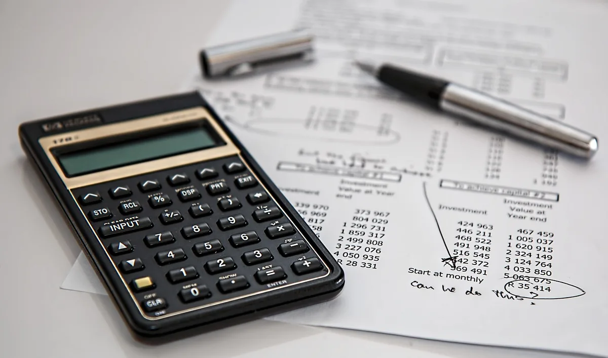 Personne organisant son budget avec calculatrice et papiers