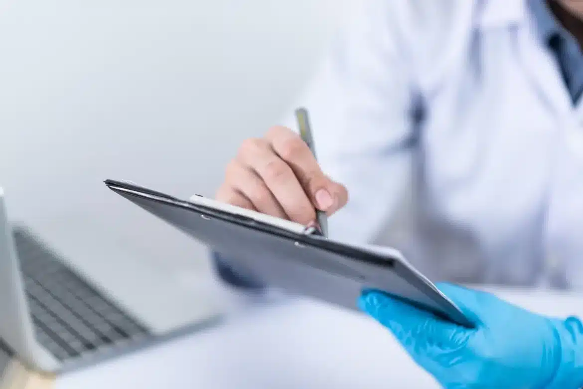 Personne anonyme signant des documents de location sur une table en plein jour