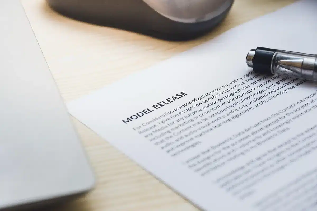 Mains anonymes signant un contrat de location sur une table lumineuse
